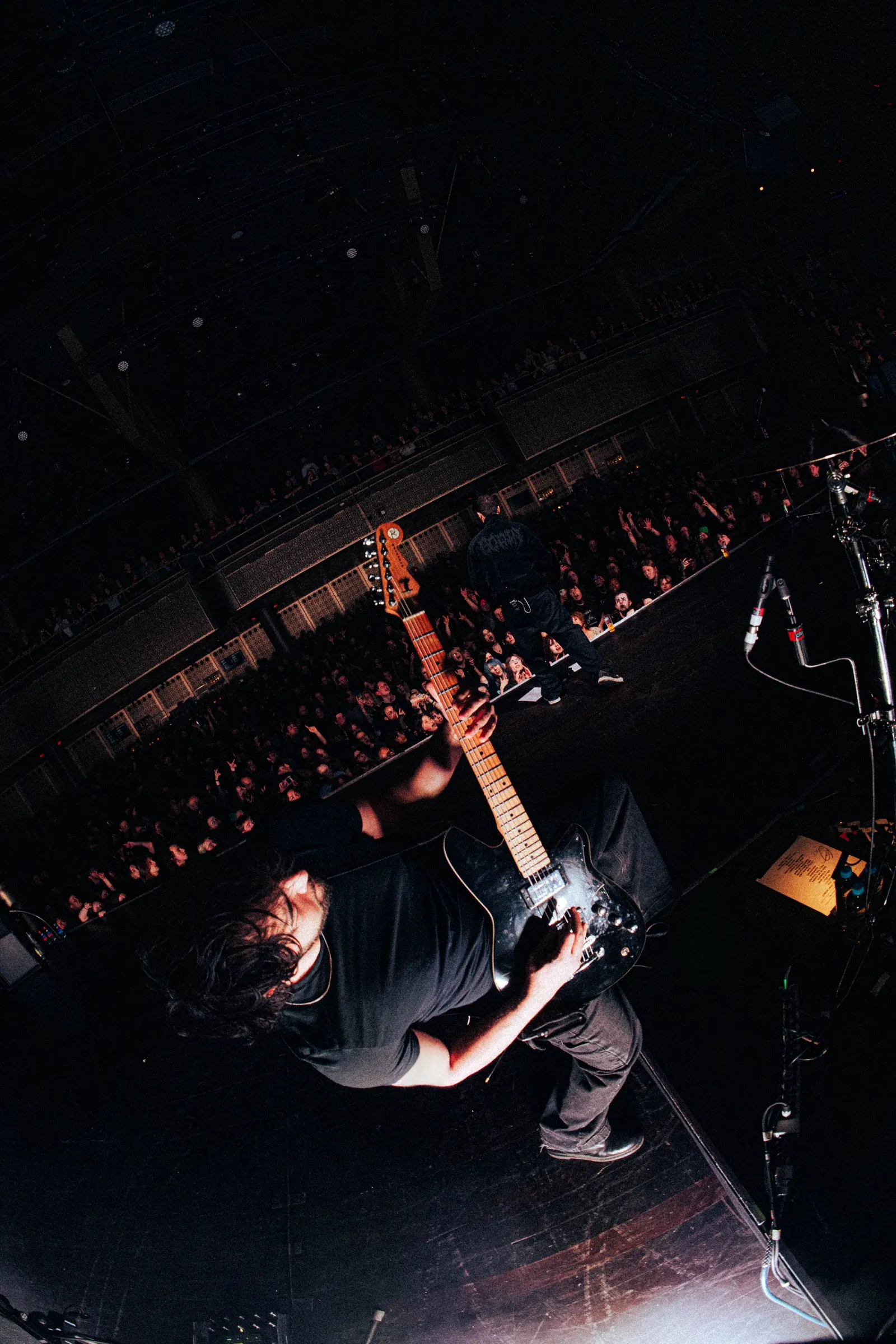 Overhead view of Amin Mortada playing guitar with crowd behind